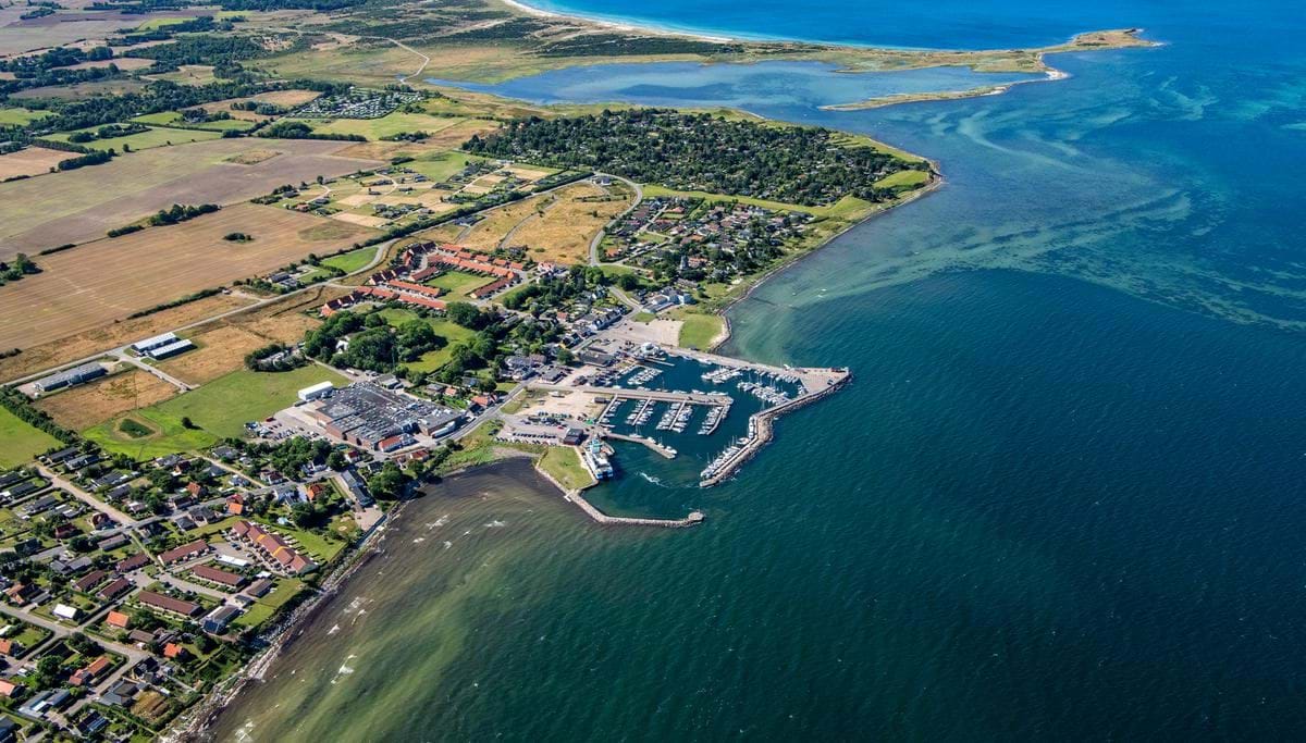 Luftfoto af Havnsø, hvor boligområder, sommerhusområder og havn ses.